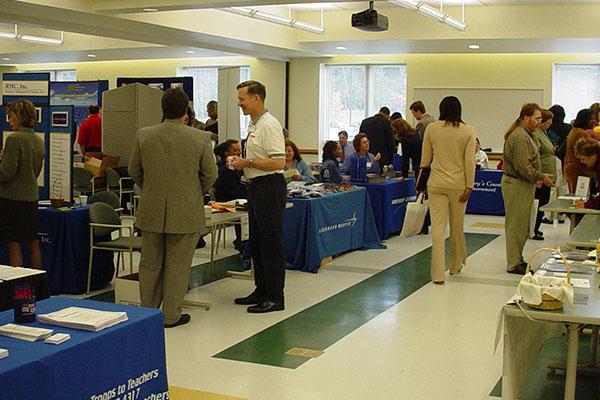 Business professionals in a room with exhibits on tables